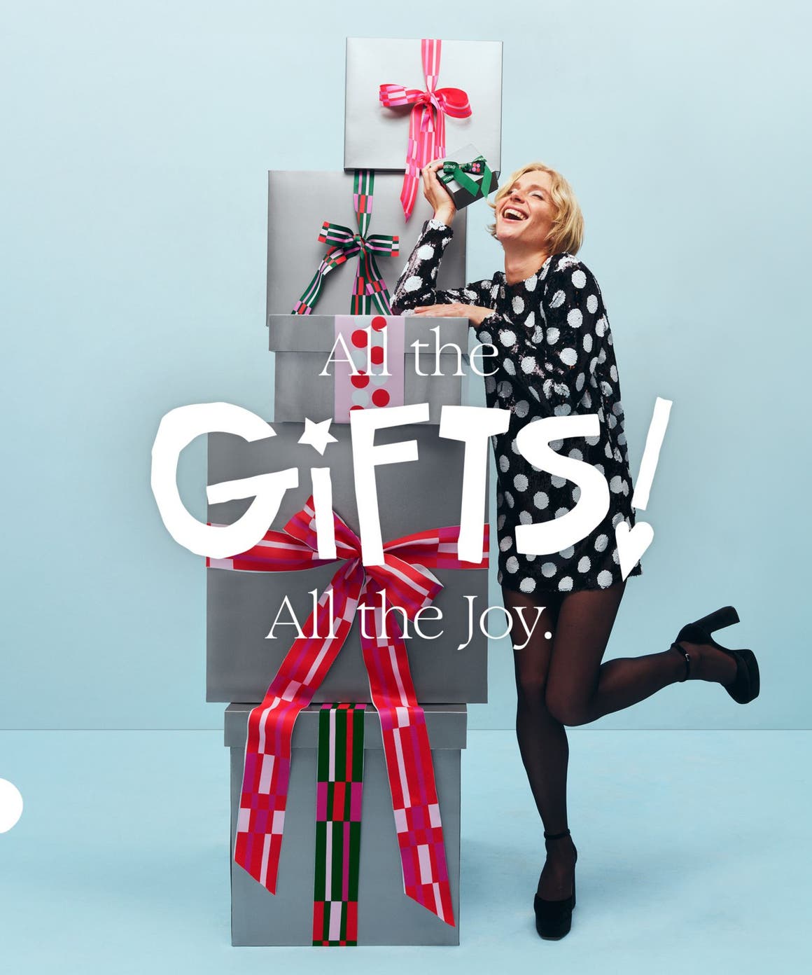 All the gifts! All the joy. A woman with a stack of gift boxes.