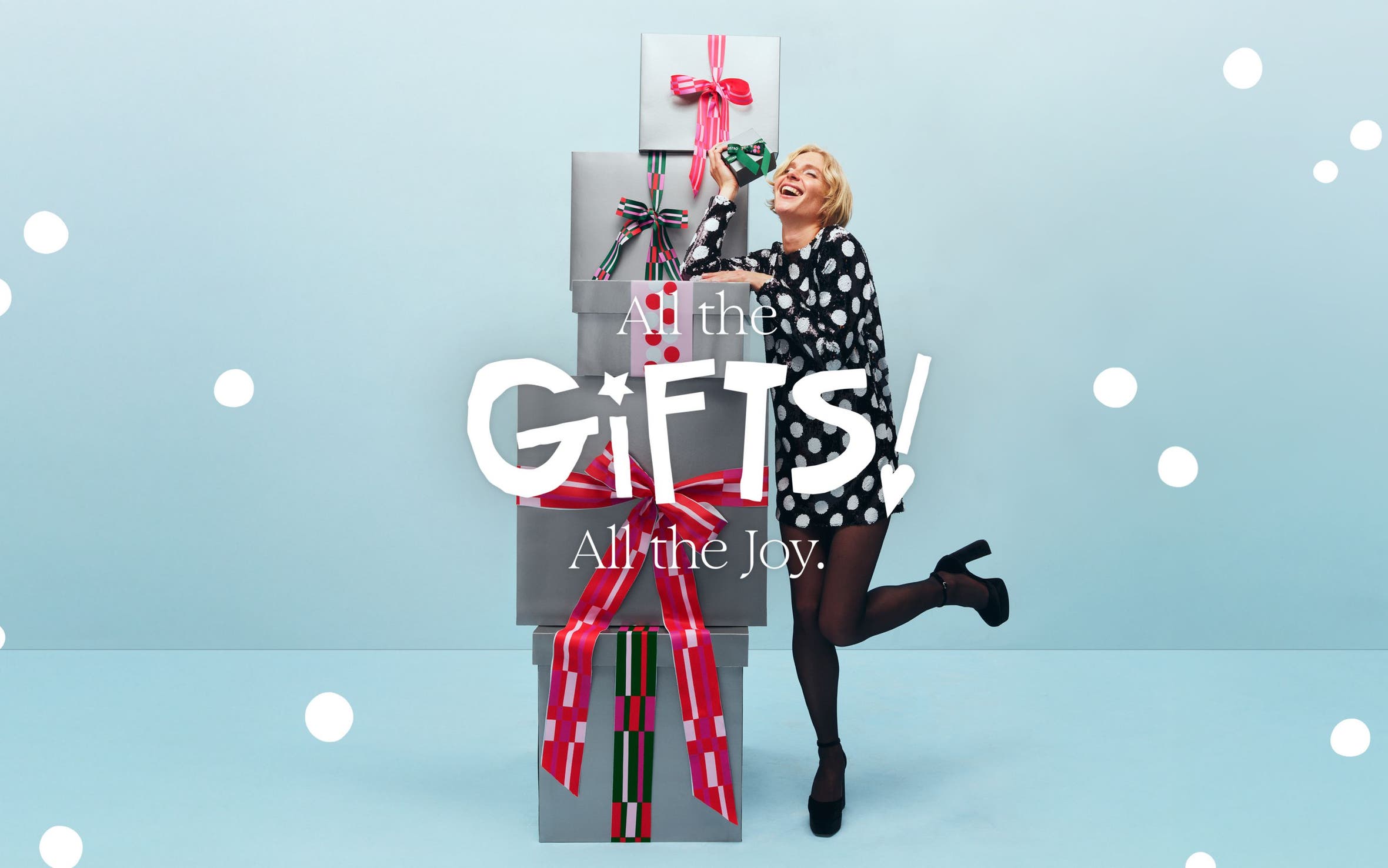 All the gifts! All the joy. A woman with a stack of gift boxes.