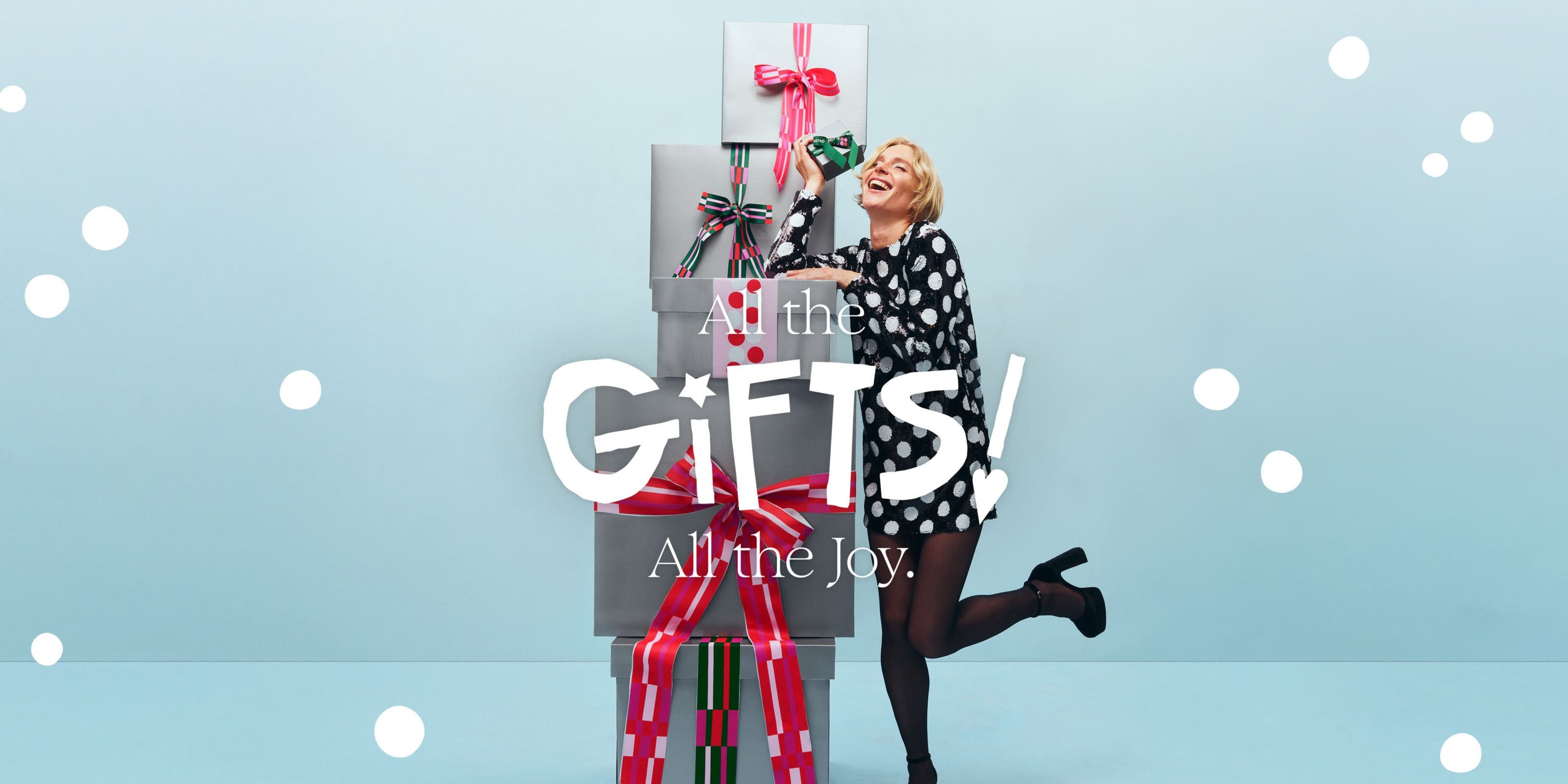 All the gifts! All the joy. A woman with a stack of gift boxes.