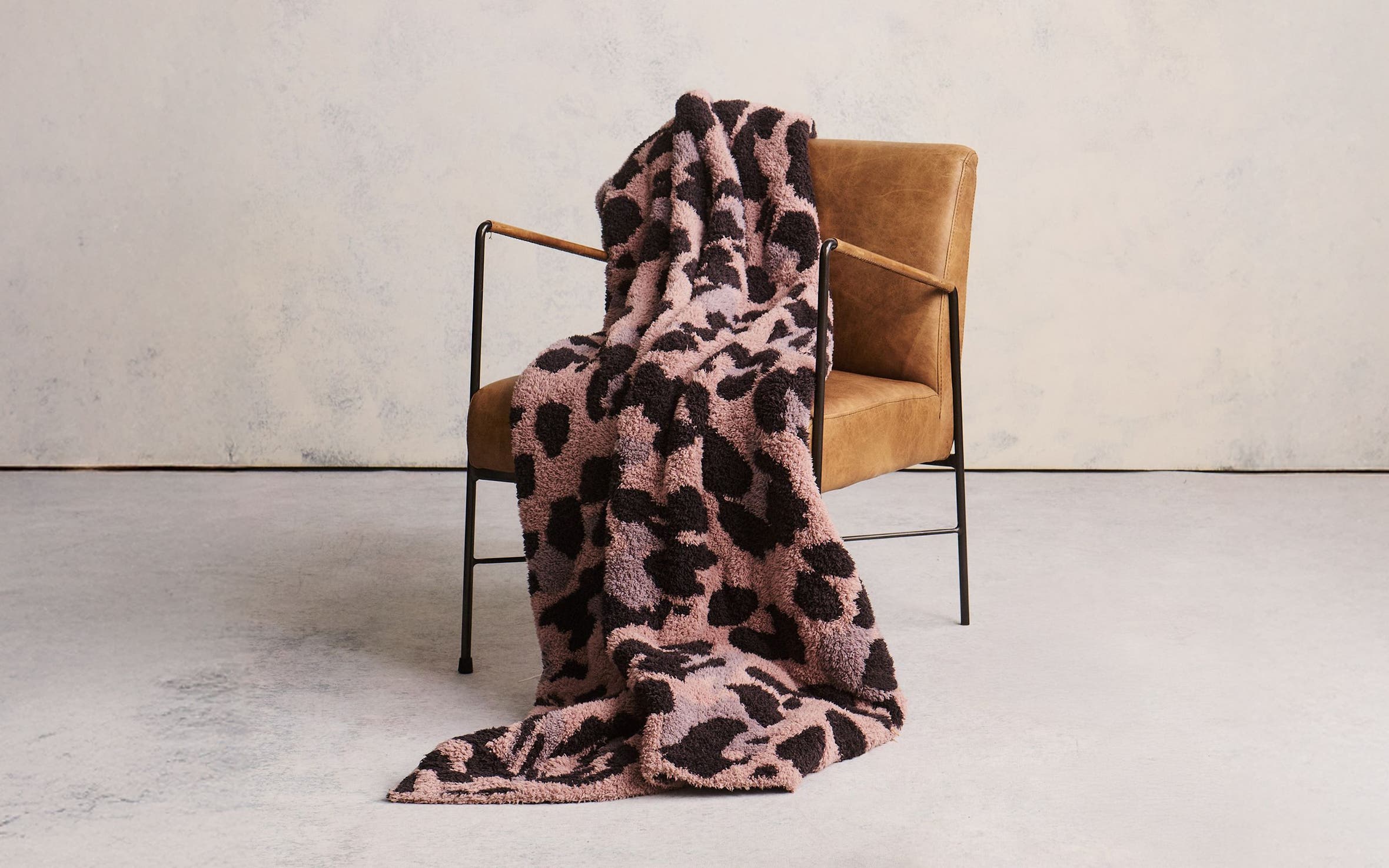 An animal-print blanket draped over a chair.