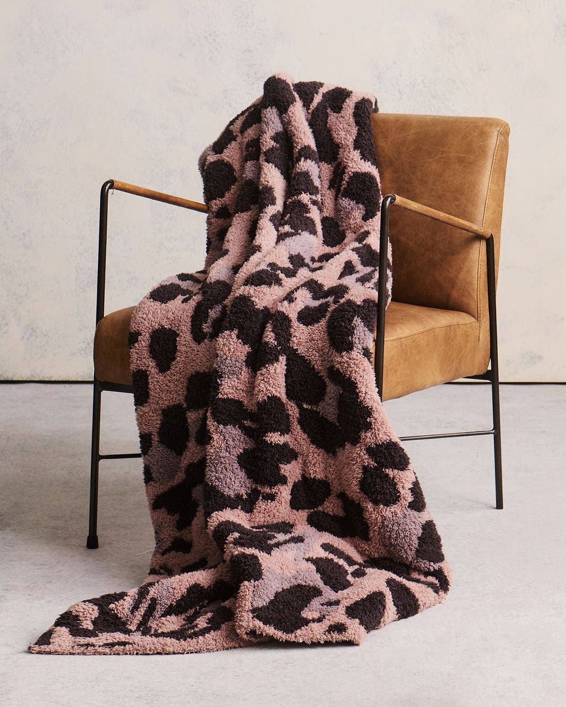 An animal-print blanket draped over a chair.