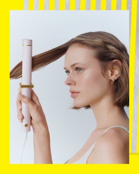 A woman using a curling iron.