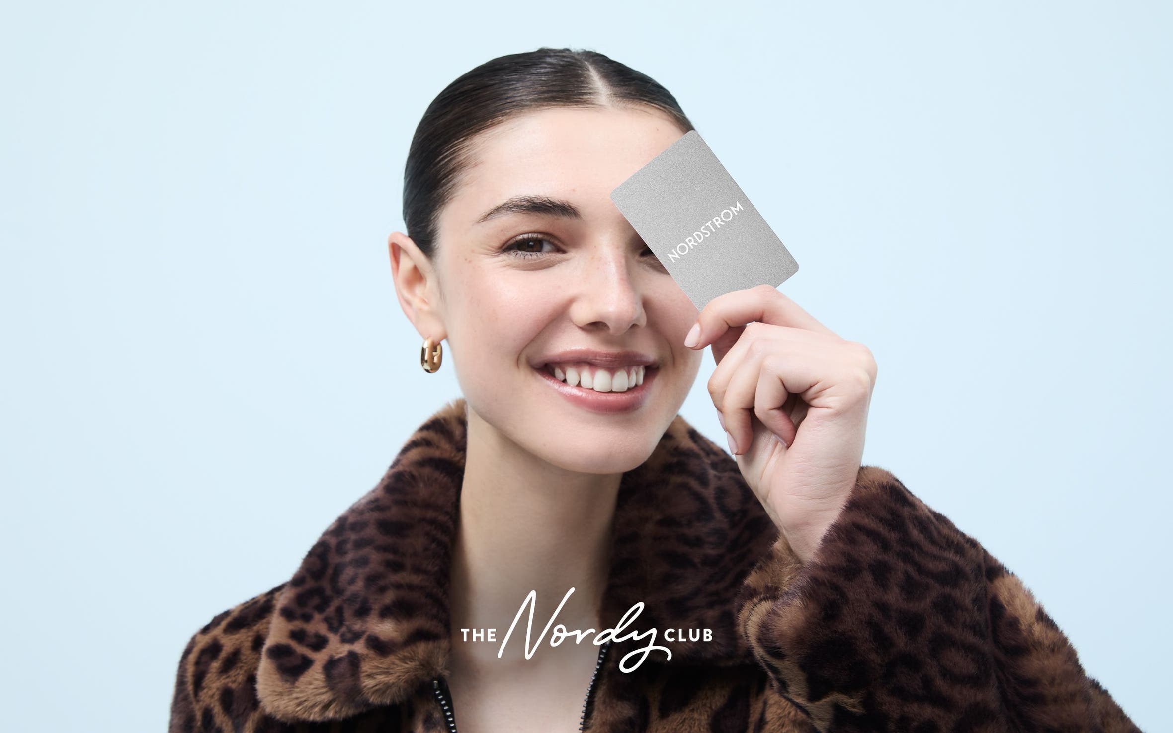 Woman holding a Nordstrom Visa credit card.