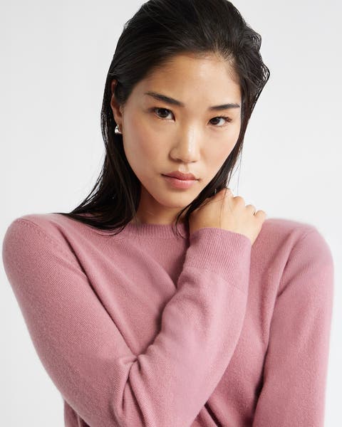 Woman wearing a mauve cashmere sweater.