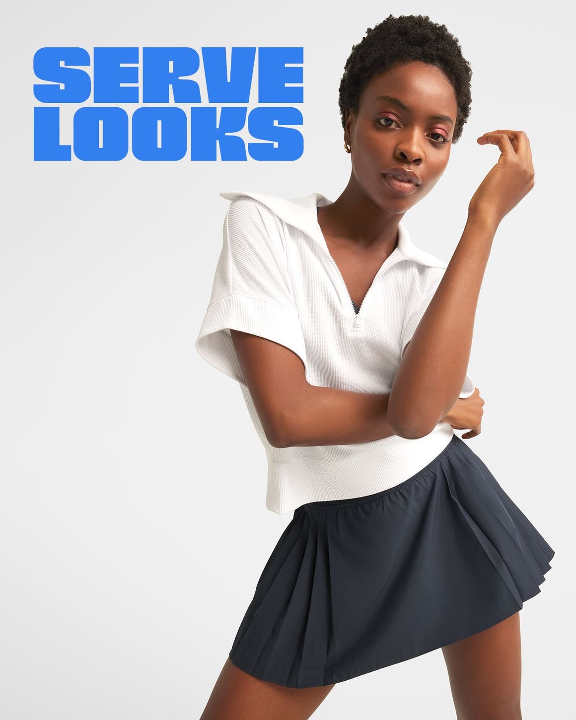 A woman wearing an active top and skirt.