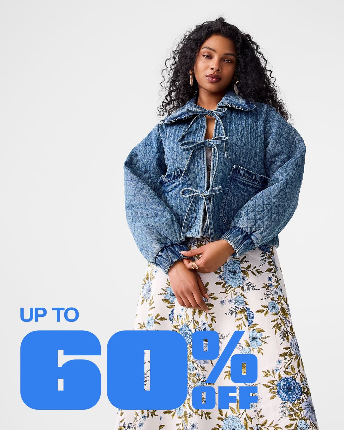A woman wearing a quilted denim jacket and a floral skirt.