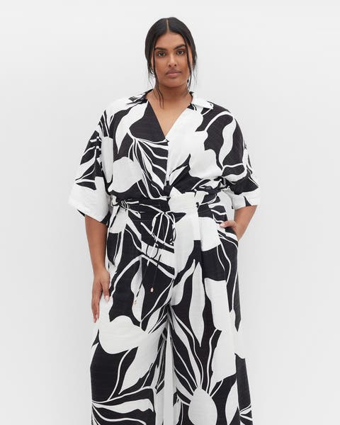 Woman in a black-and-white printed plus-size jumpsuit.