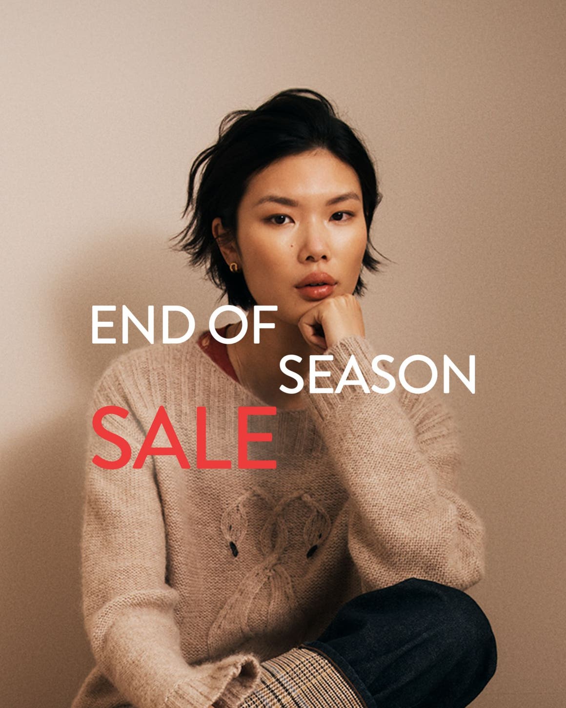 End-of-season sale. A woman wearing a cozy sweater.