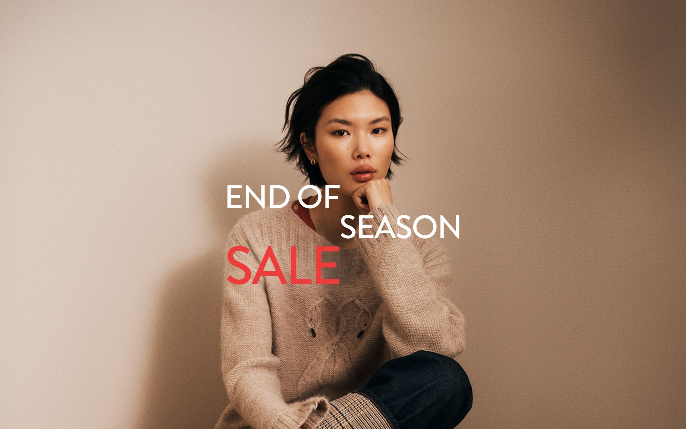 End-of-season sale. A woman wearing a cozy sweater.