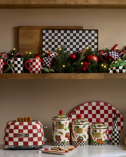 MacKenzie-Childs Courtly Check holiday kitchen scene with checkered toaster, canisters, mugs, serving platter, and evergreen garland with red ornaments
