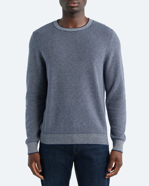 Man wearing a crewneck sweater.