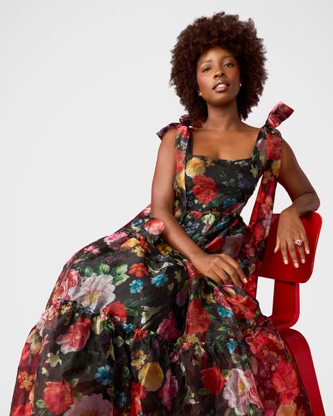 A woman wearing a black floral dress.