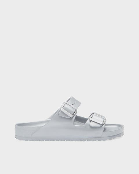 A grey buckled sandal.