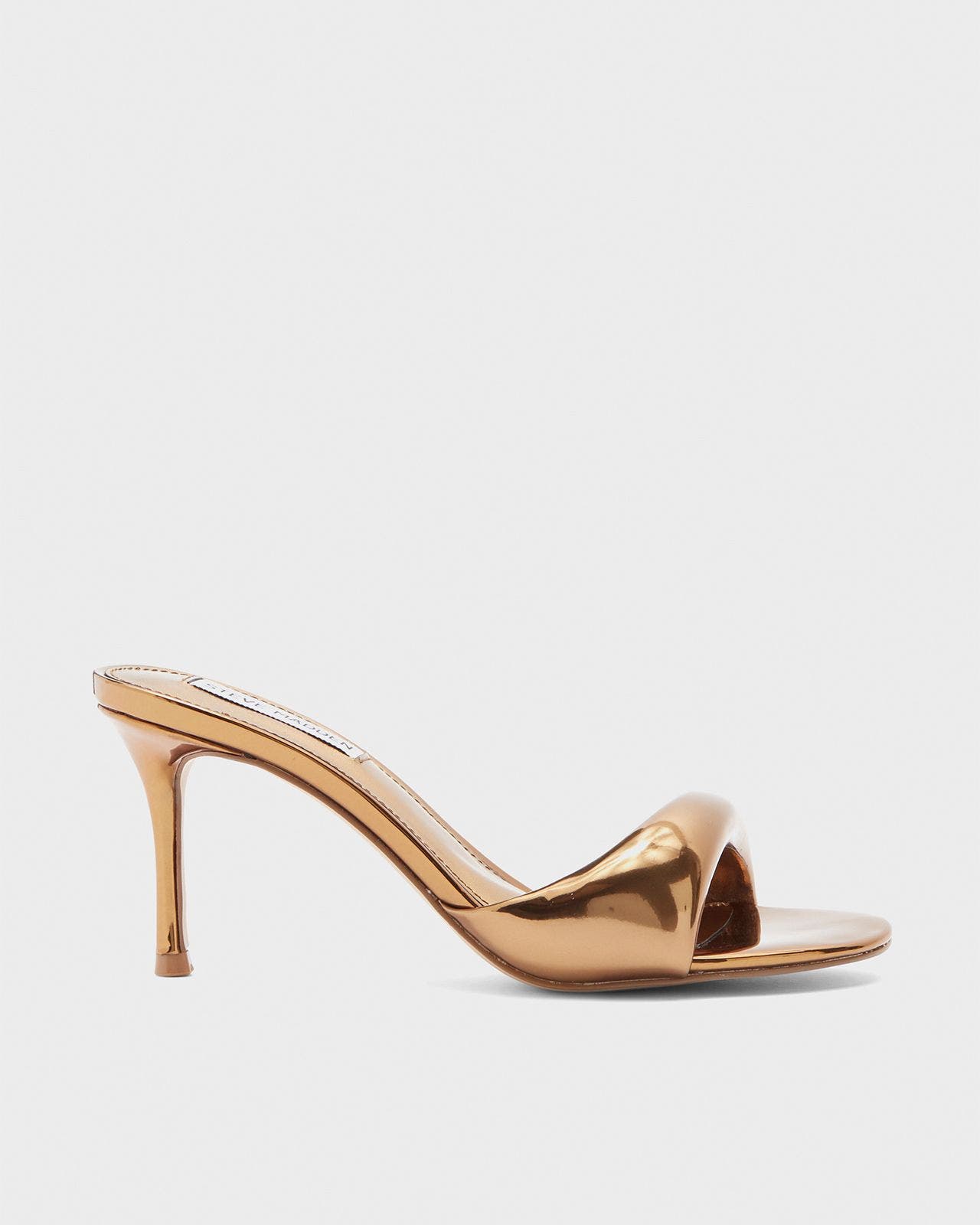 A gold sandal with a high heel.