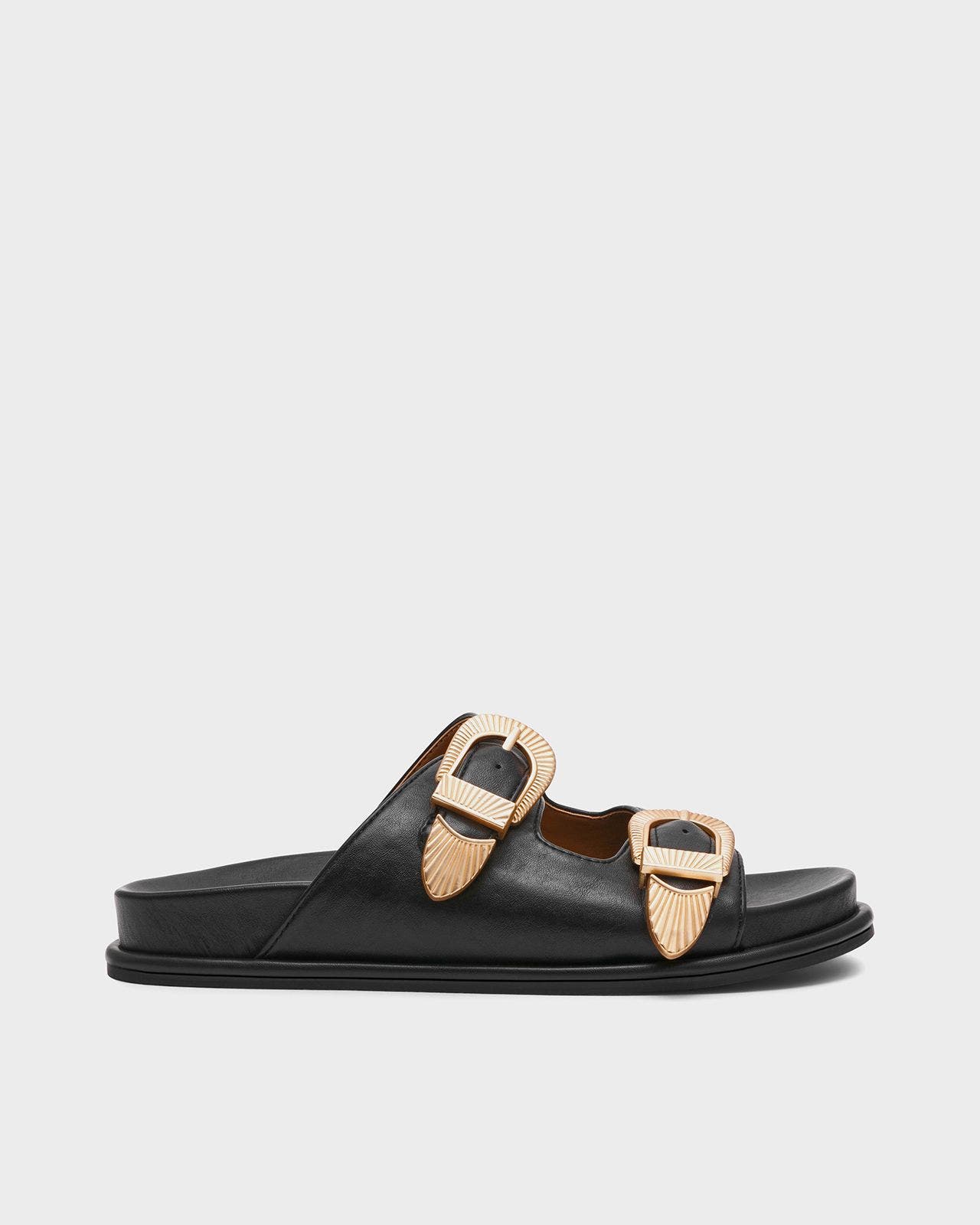 A black sandal with golden buckles.