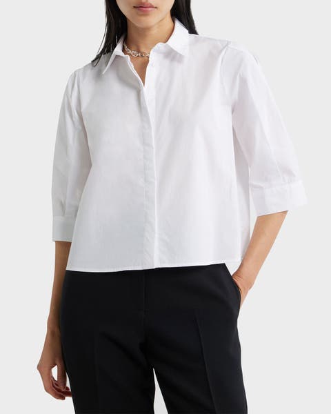 A woman wearing a white shirt with black pants.
