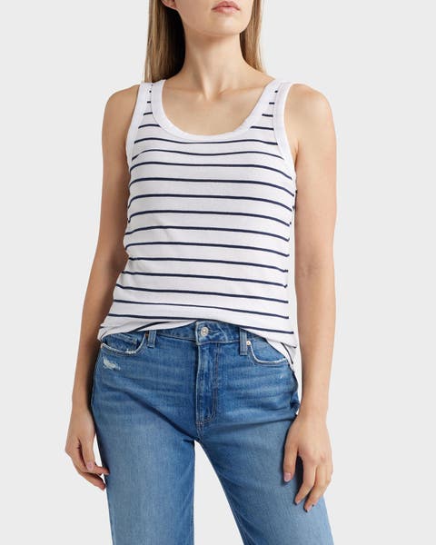 A woman wearing a striped tank with jeans.