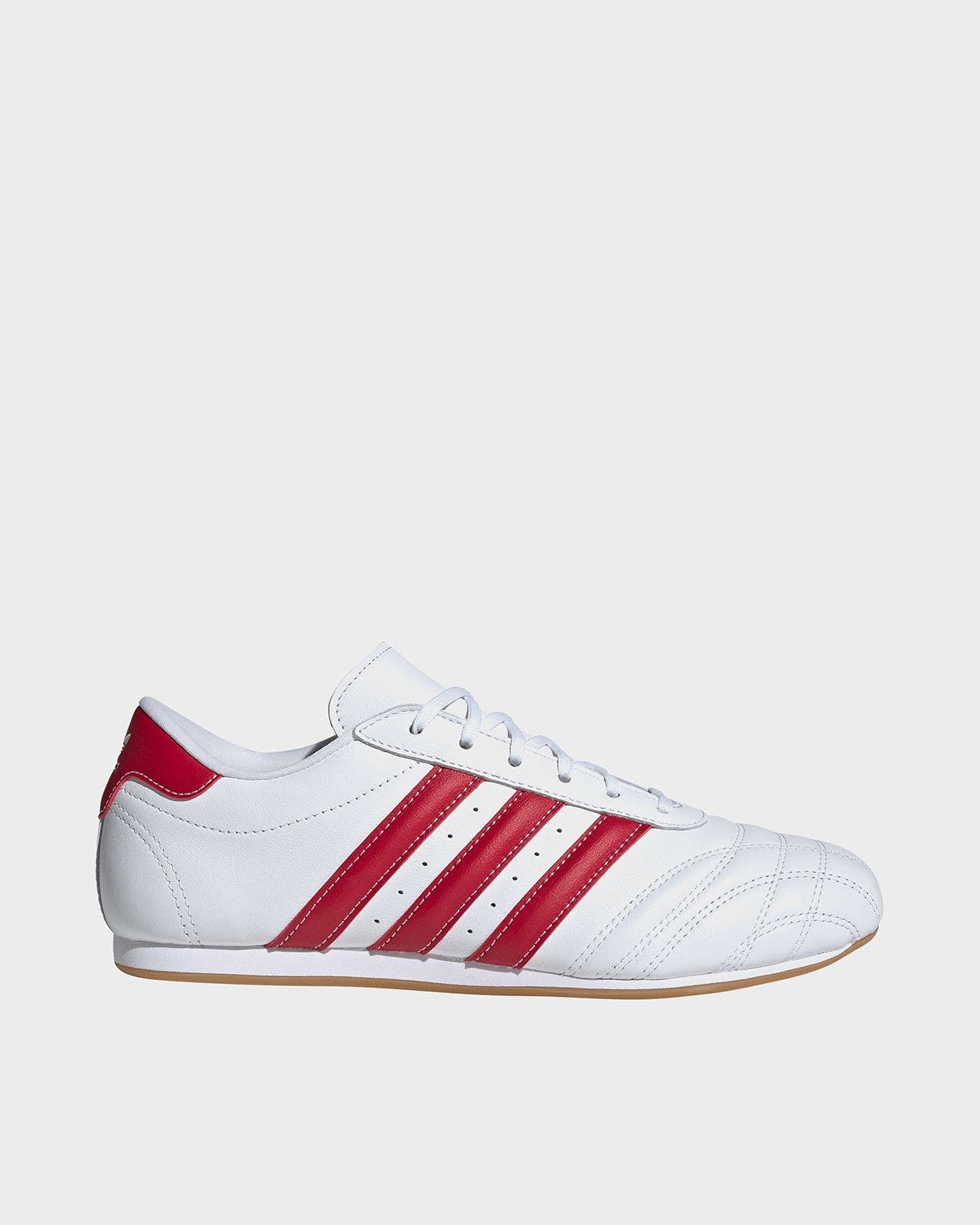 A white adidas sneaker with red stripes.