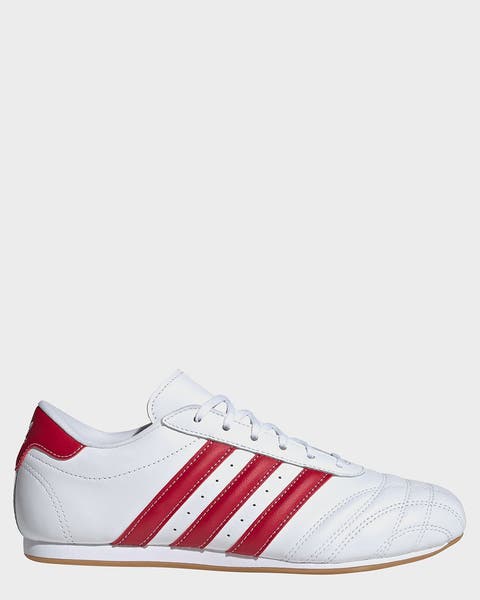 A white adidas sneaker with red stripes.