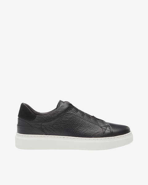 A black slip-on sneaker. 
