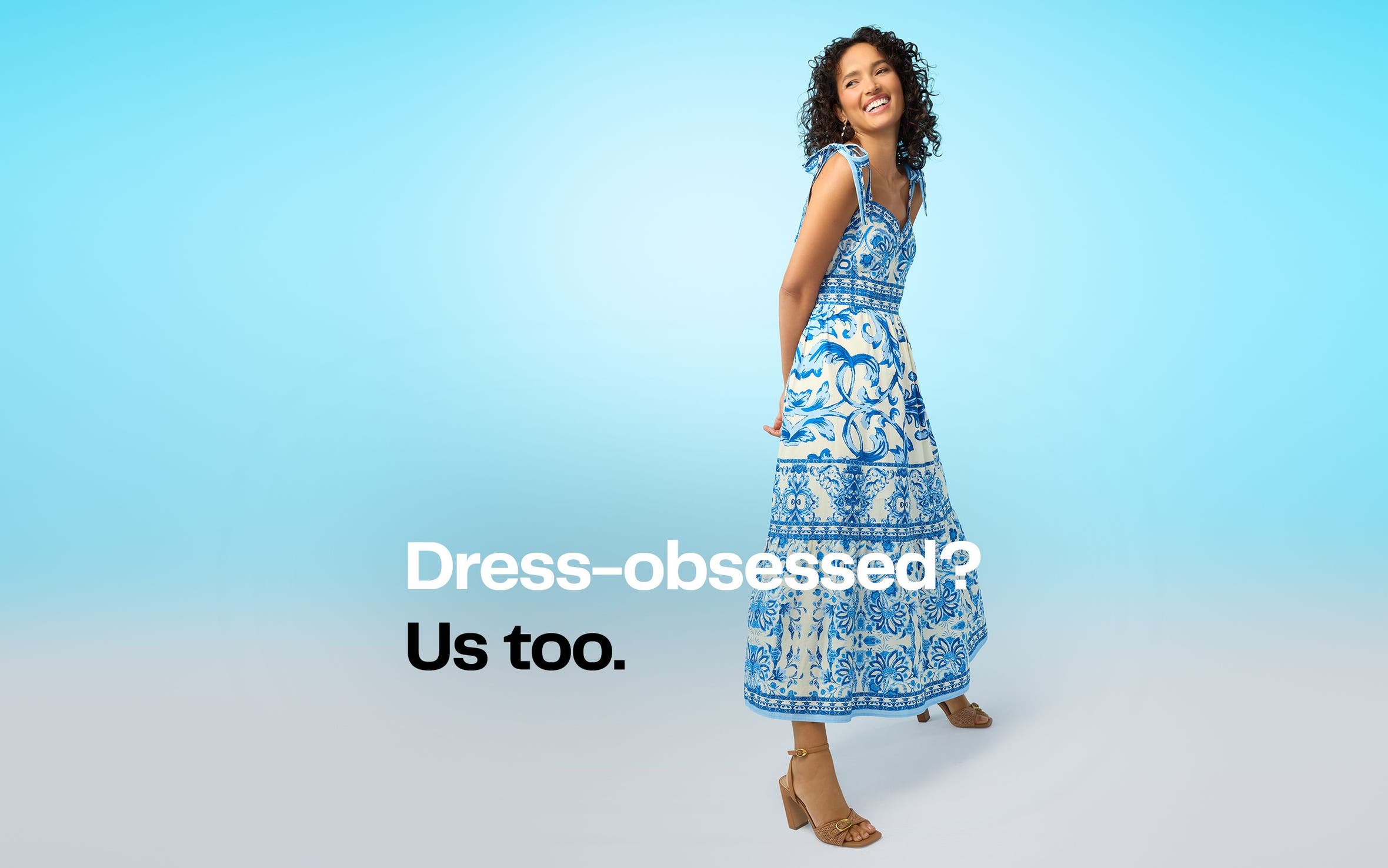 A woman wearing a blue-and-white sundress and brown ankle-strap sandals.
