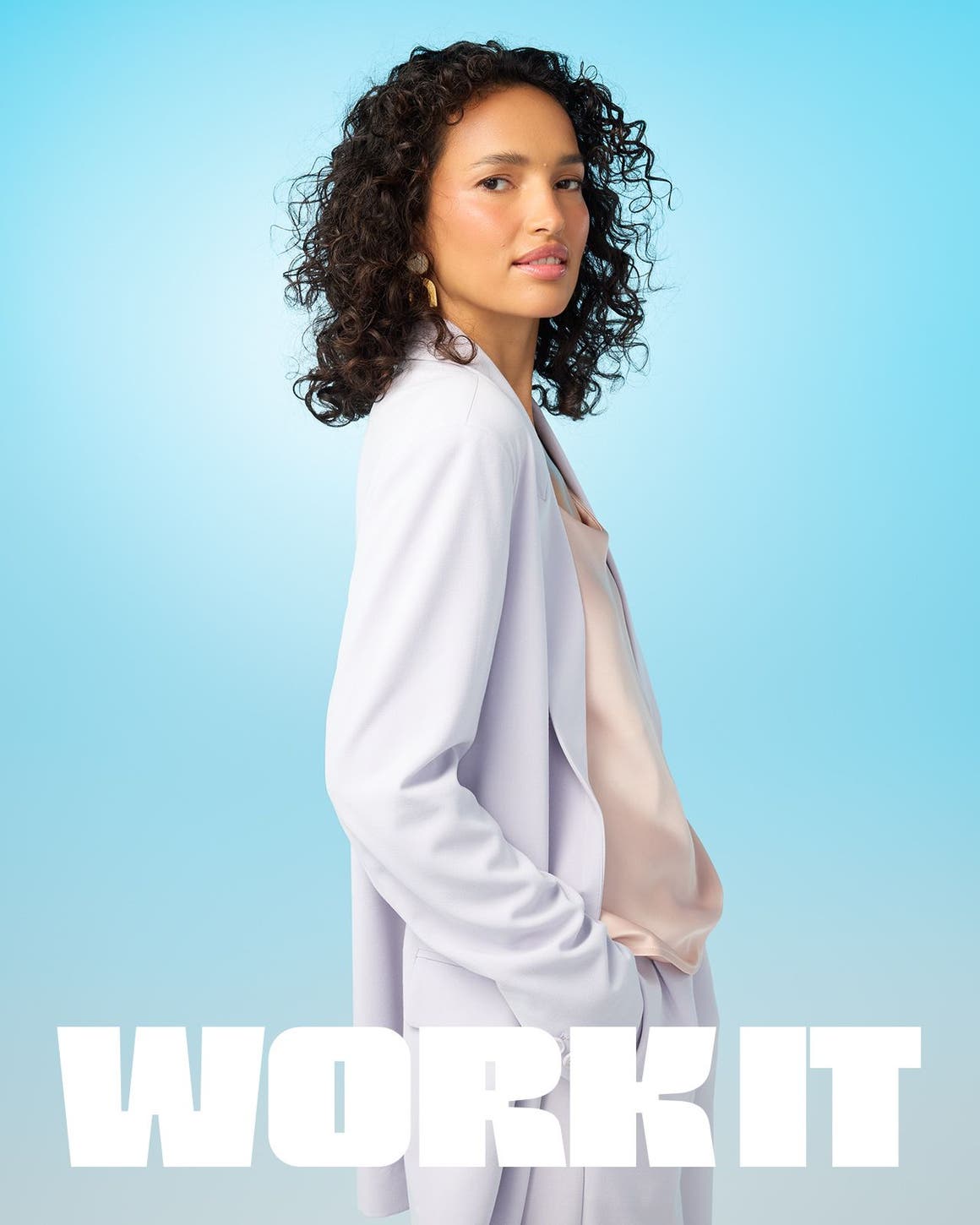 A woman wearing a light peach top and a lavender suit.