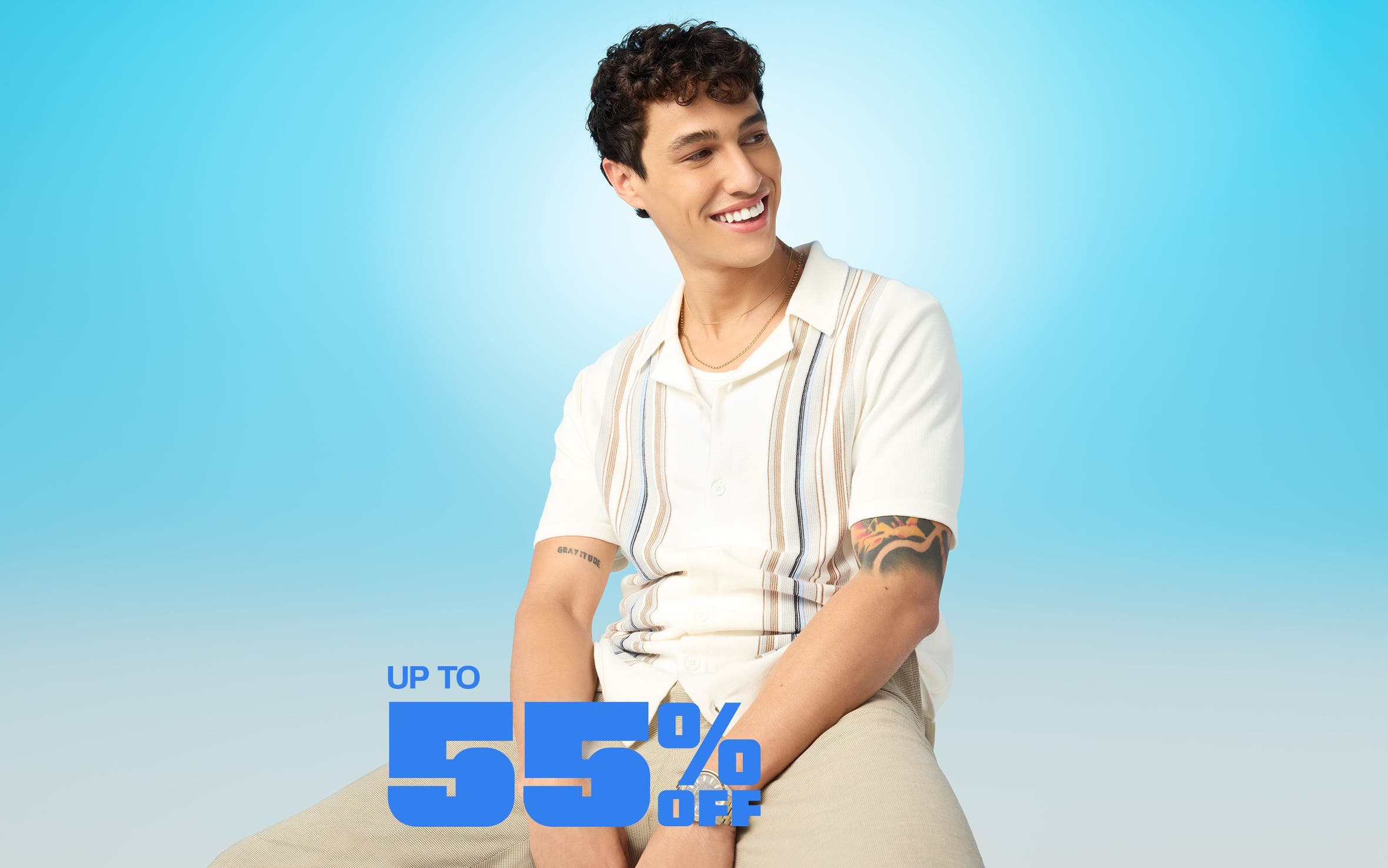 A man wearing a striped, knit cardigan and khaki pants.