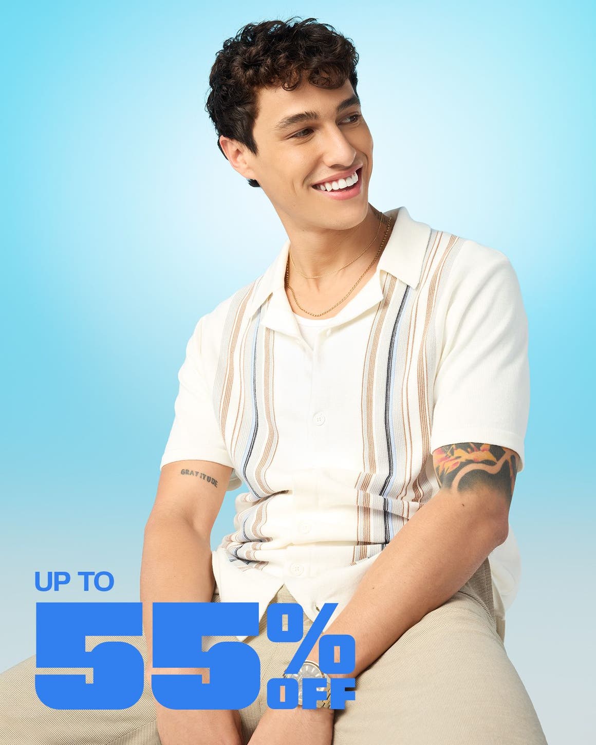 A man wearing a striped, knit cardigan and khaki pants.