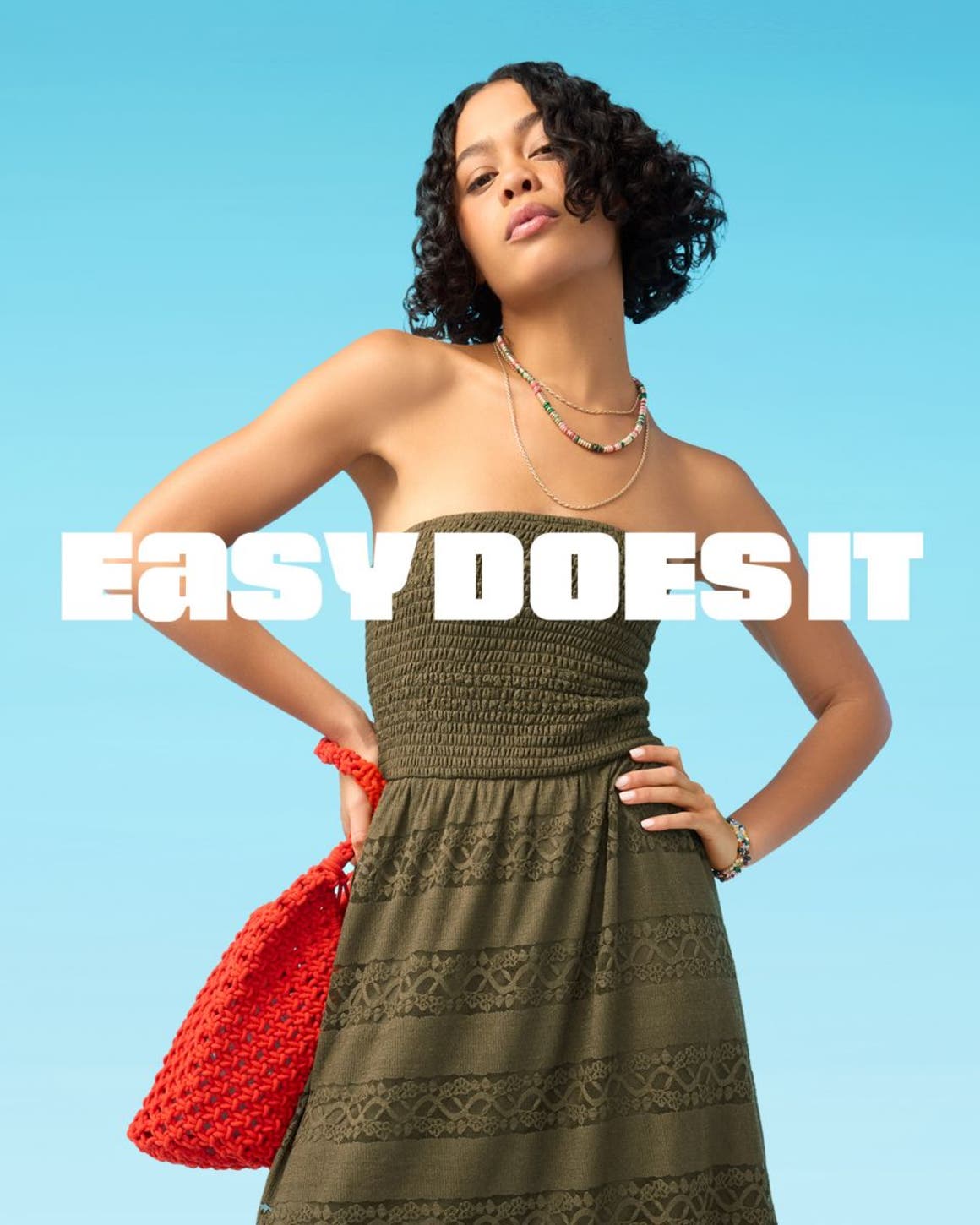 A woman wearing a strapless bustier top, green drawstring pants and woven thong sandals.