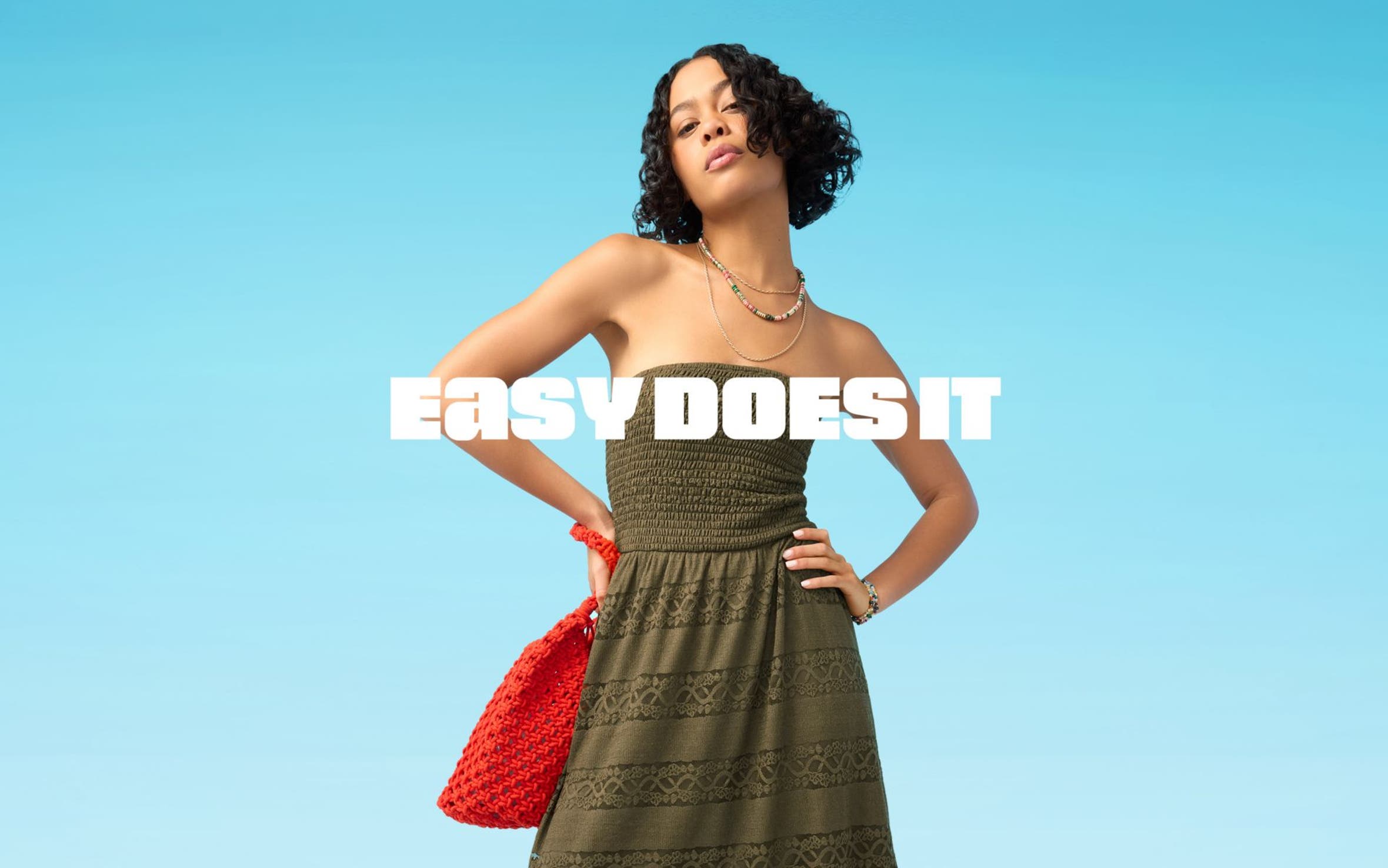 A woman wearing a strapless bustier top, green drawstring pants and woven thong sandals.