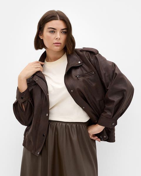 Woman wearing a brown plus-size jacket and white tee.