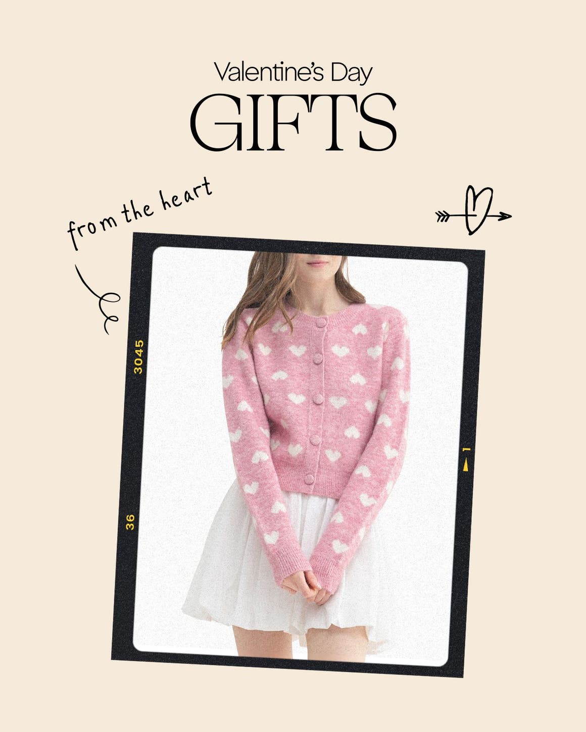 A woman wearing a pink cardigan with white hearts and a white skirt. 