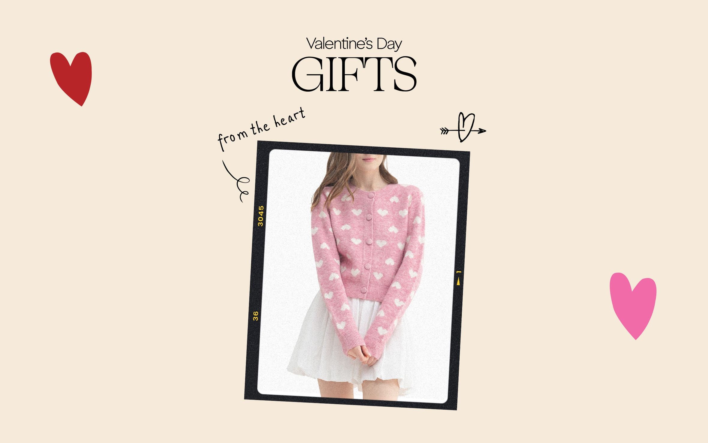 A woman wearing a pink cardigan with white hearts and a white skirt. 