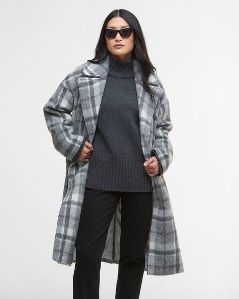 Woman wearing a grey plaid knee length wool coat.