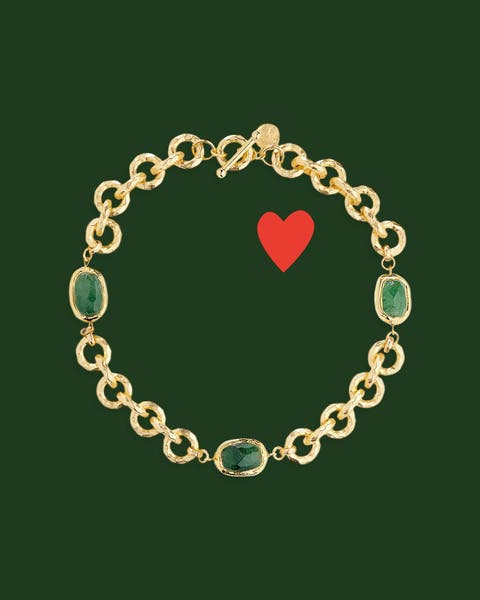 A gold necklace with green stones.