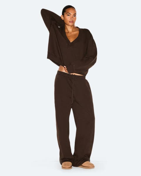 A woman wearing a matching sweatshirt and sweatpants with slippers.