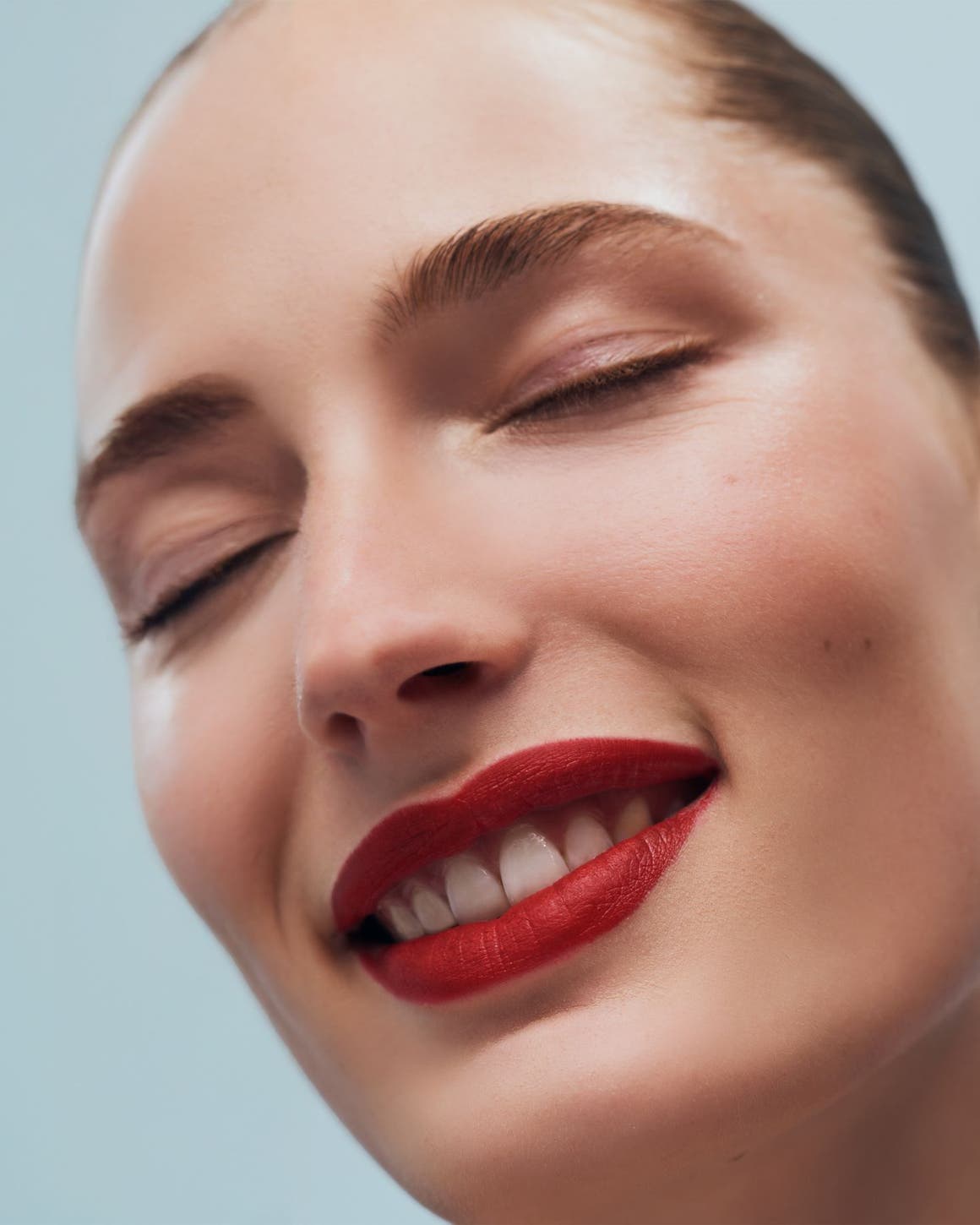 A woman smiling with eyes closed.