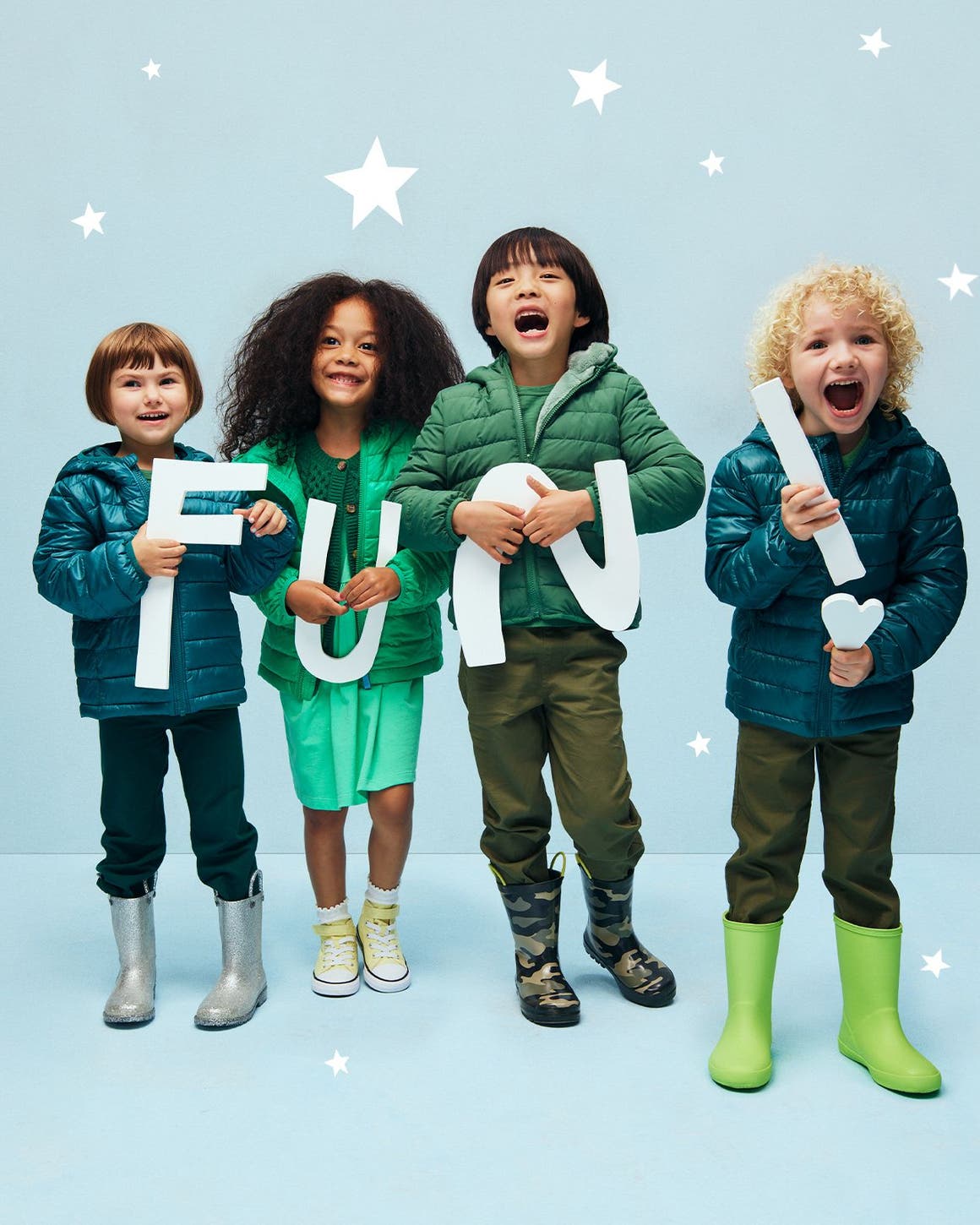 Kids in winter jackets holding letters that spell FUN