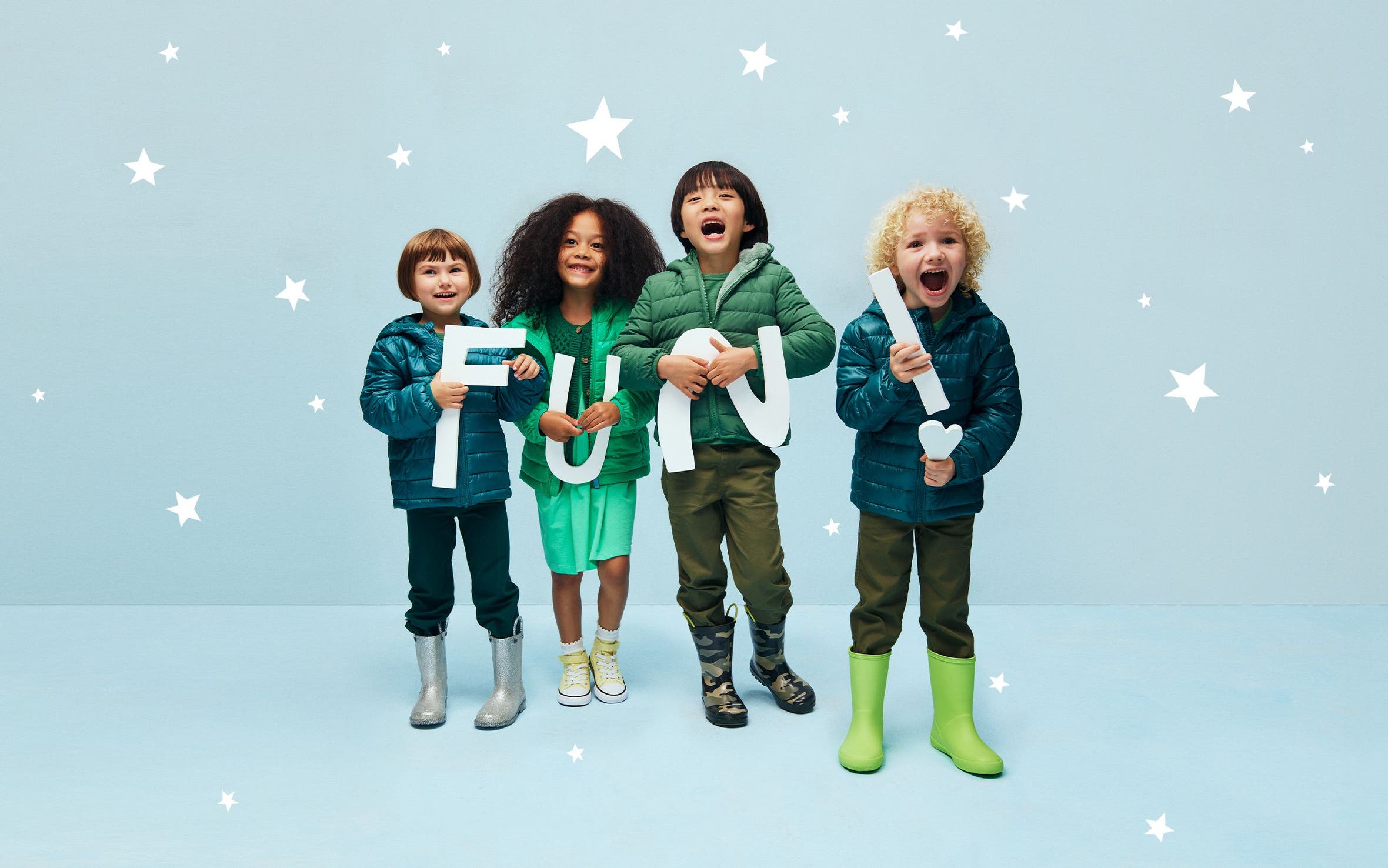 Kids in winter jackets holding letters that spell FUN