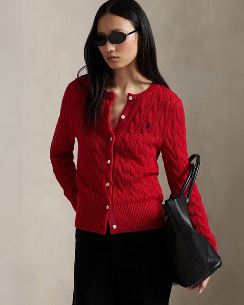 A woman wearing a red cardigan.