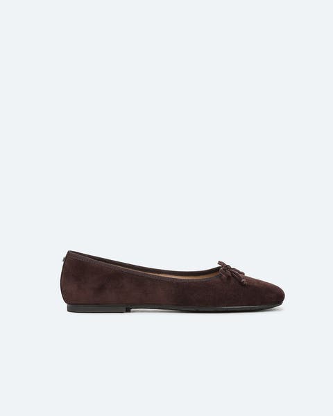 A pair of dark brown suede flats. 