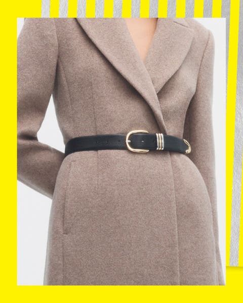 A woman in a wool wrap coat cinched at the waist with a skinny black belt.