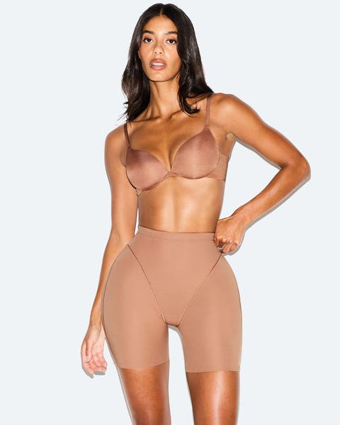 A woman wearing a bra and shapewear shorts.