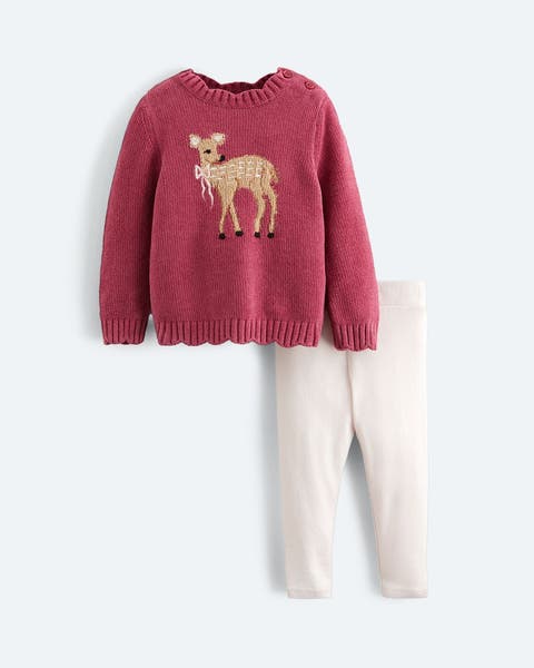 Pink graphic sweater and white pants.