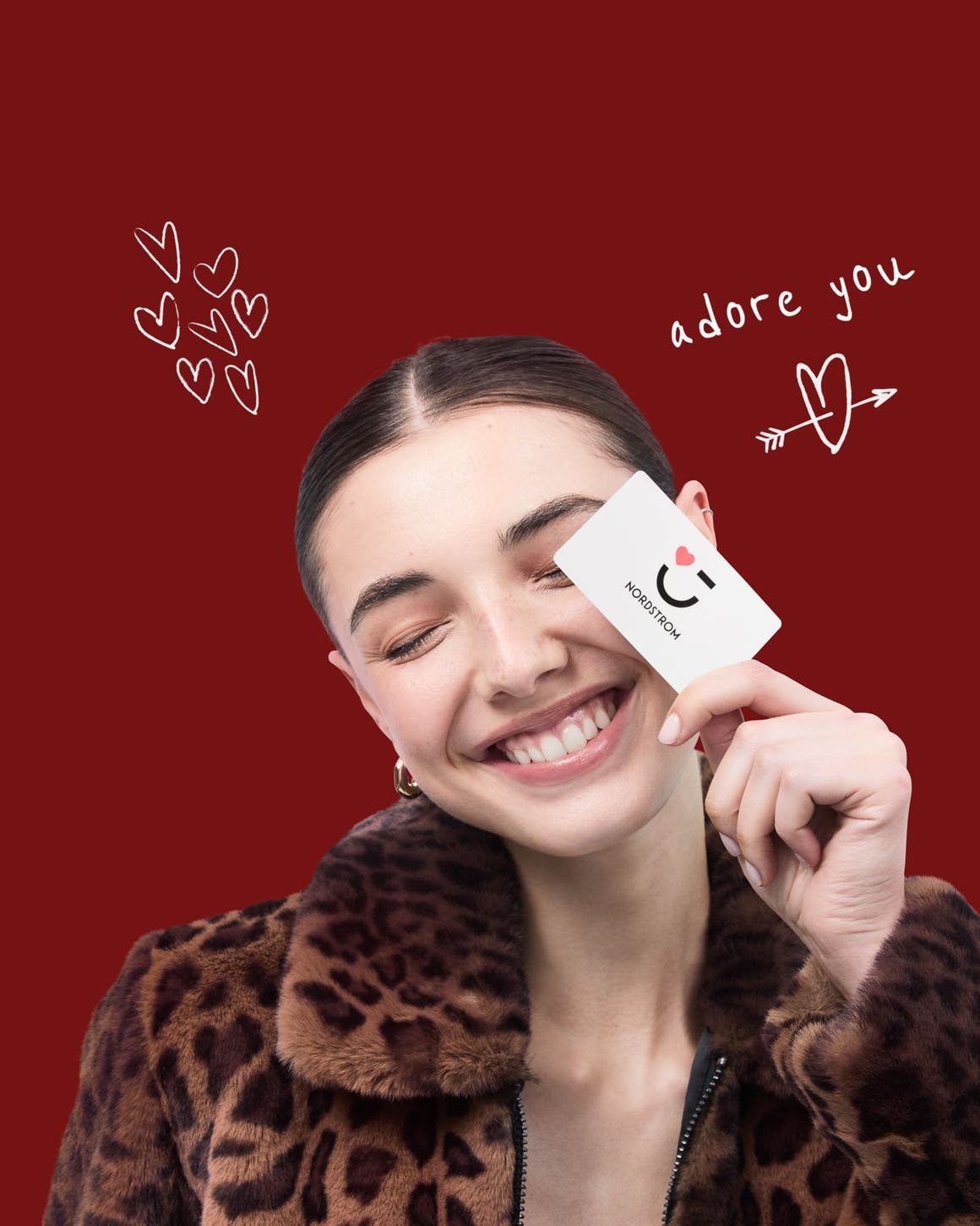 Woman smiling with a Nordstrom gift card.