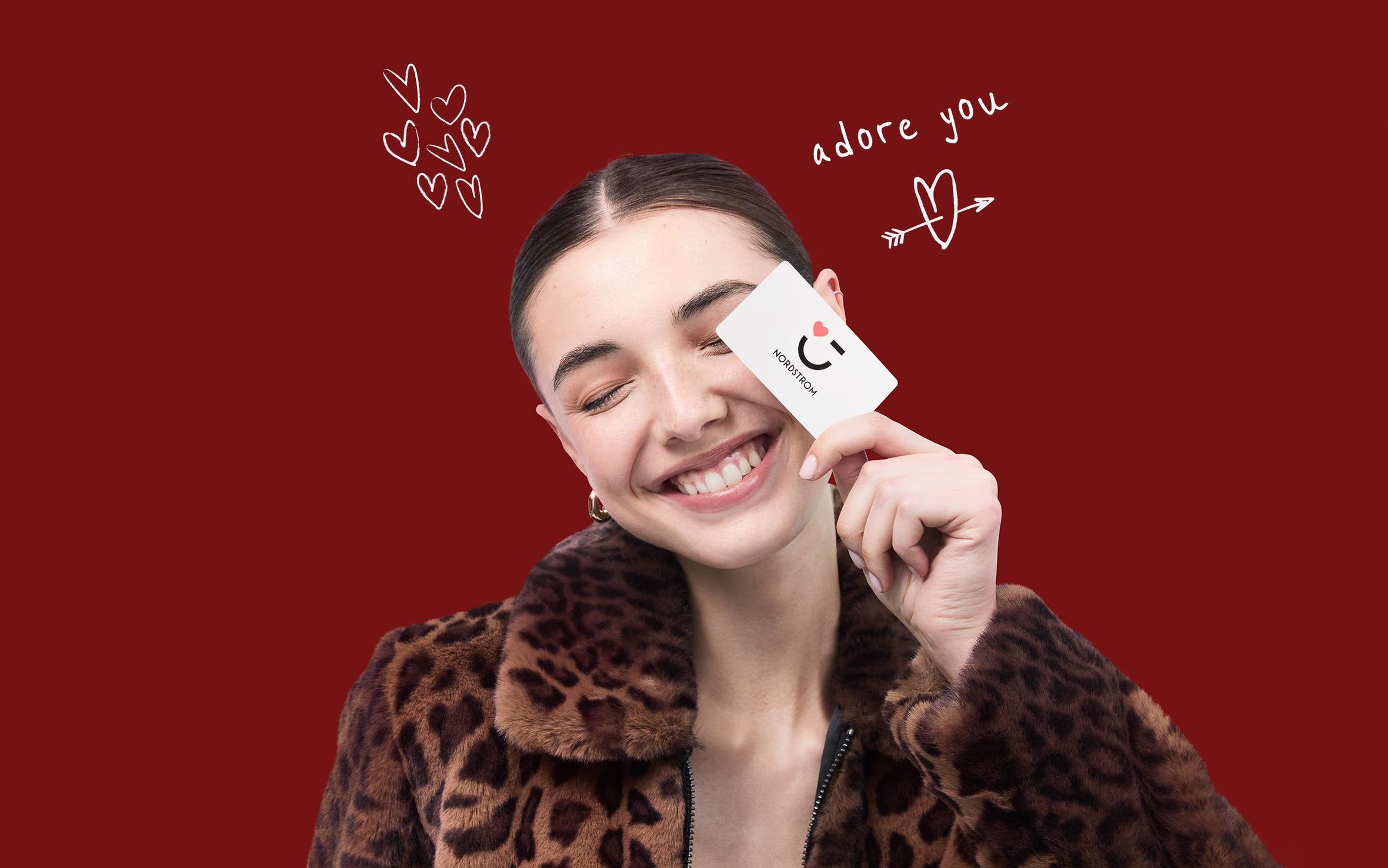 Woman smiling with a Nordstrom gift card.
