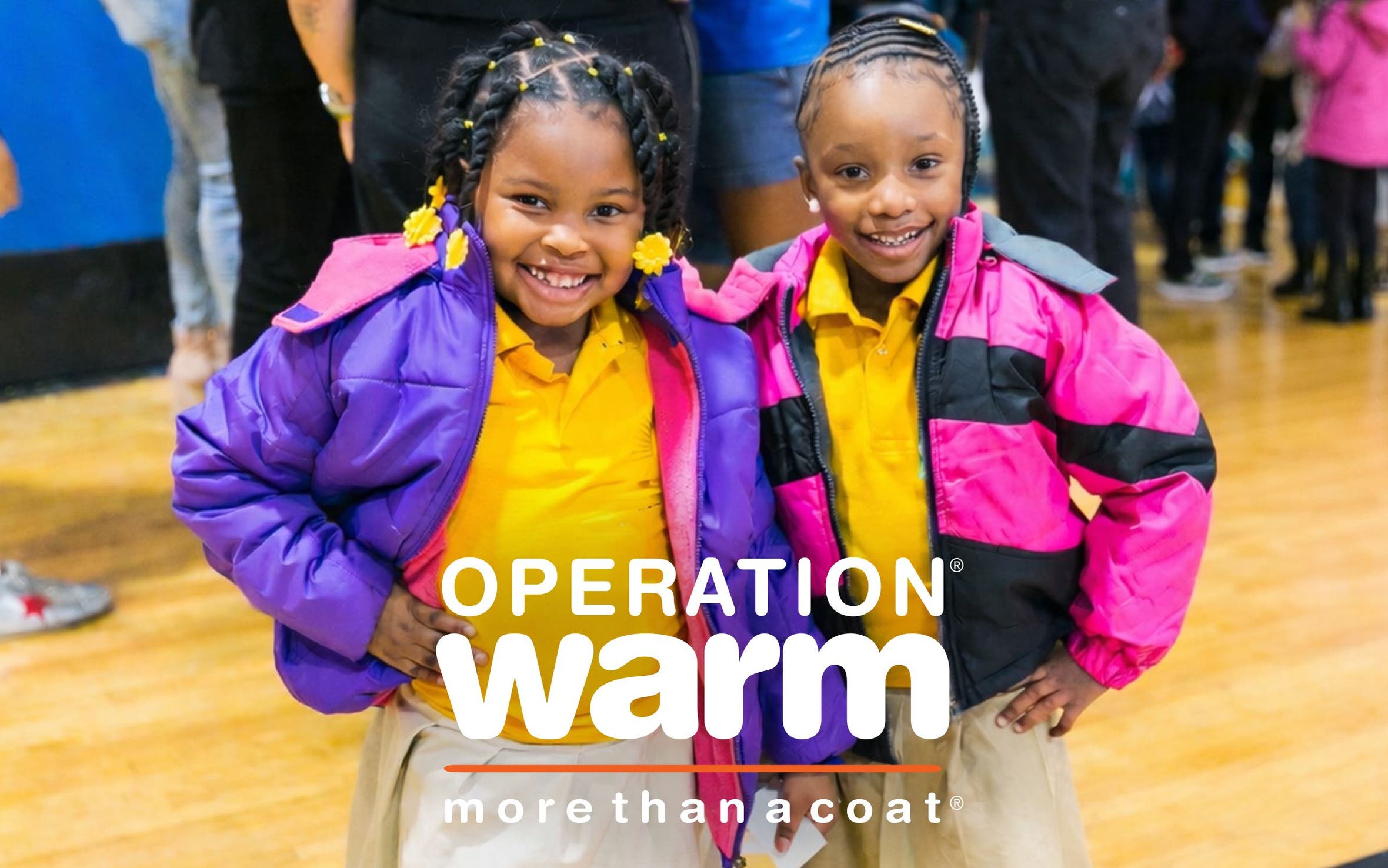Help support Operation Warm. Two little girls smiling and wearing colorful coats.
