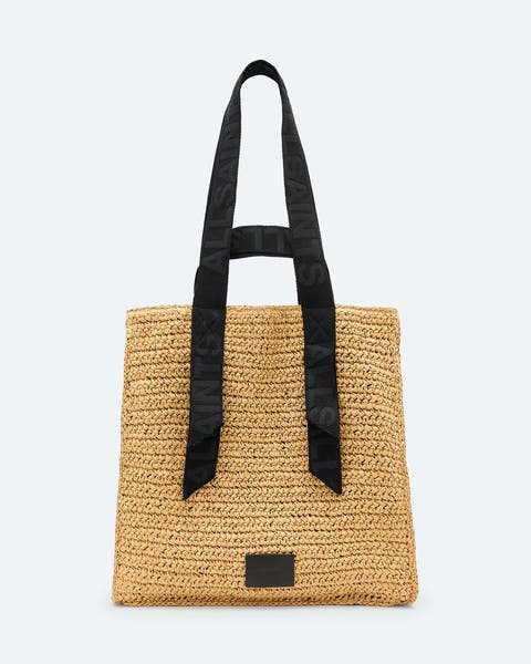 A woven straw tote with black handles.