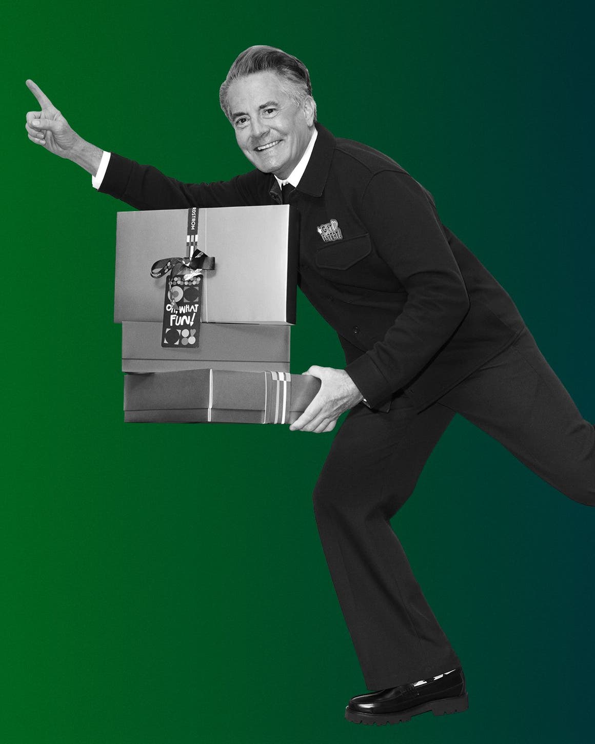 Kyle MacLachlan holding a stack of gift boxes.