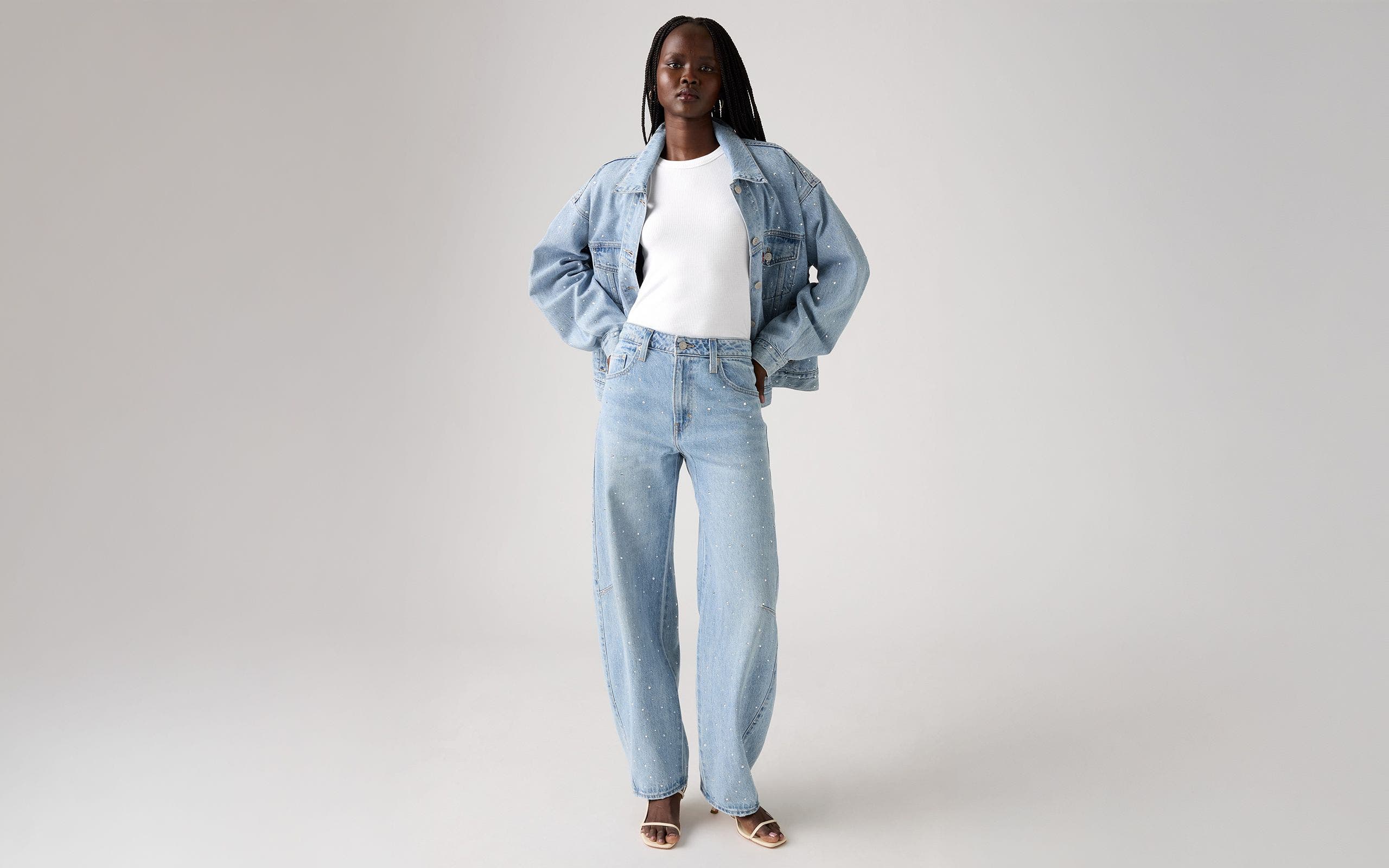 Alt text: A woman wearing an embellished denim jacket and matching jeans.